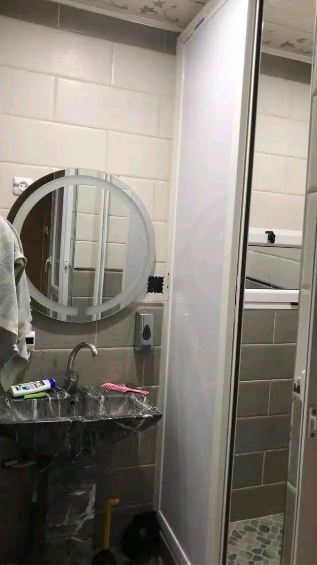 Baño con espejo iluminado y mampara